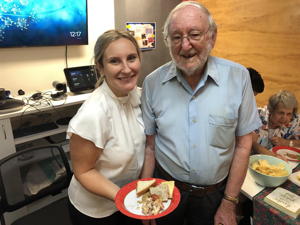 Woman and senior man smiling with plate of food